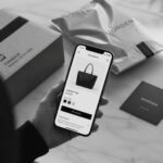Onlineshop-Produktseite auf dem Smartphone mit Versandpaketen